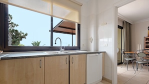 Une cuisine moderne avec des meubles en bois, un lave-vaisselle encastré et une grande fenêtre.