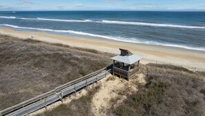 A beach with a wooden structure and a boardwalk leading to it. - 2952 - Davis - Coastal Condo in Duck Steps from the Beach (Duck)