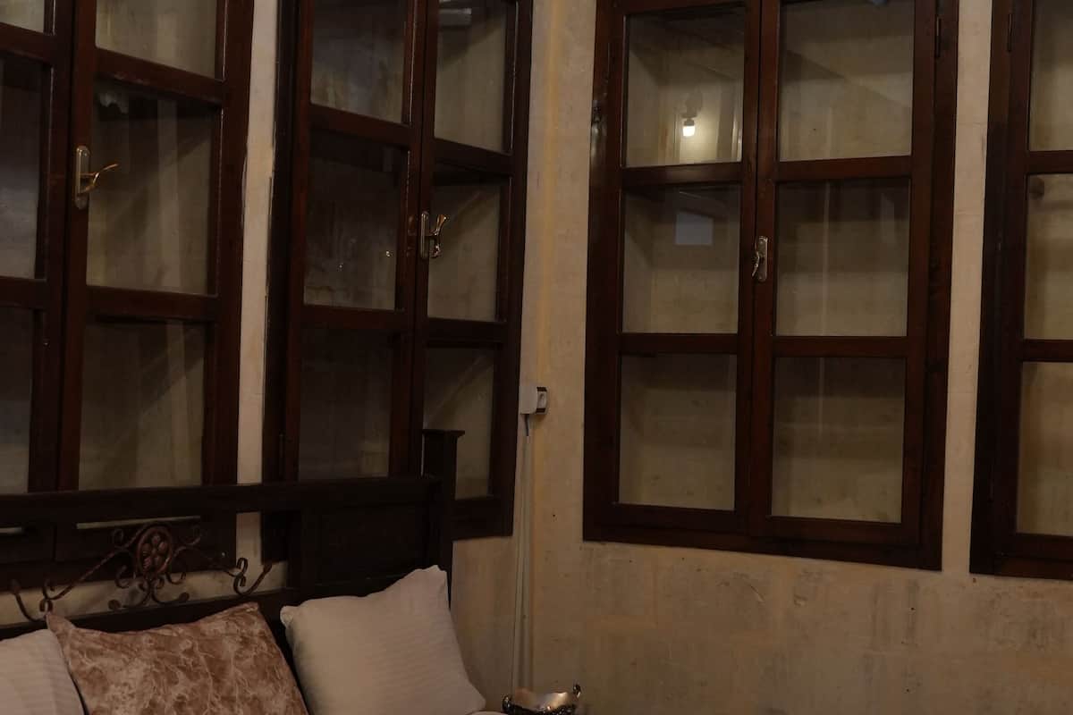 A bedroom with a large bed, wooden cabinets, and a painting on the wall.