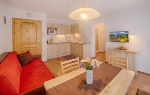 A compact living space with a kitchenette, a dining area, and a sofa.