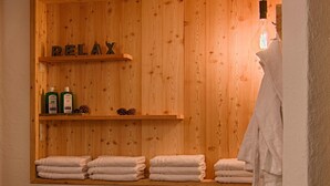 Eine Holzwand mit Regalen, auf denen Flaschen und Kiefernzapfen stehen, und das Wort 'RELAX' darüber.