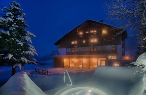 Un immeuble à plusieurs étages doté d’un balcon, d’un espace piscine et d’une terrasse en bois.