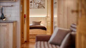 Habitación pequeña con cama, armario de madera y una zona de kitchenette.