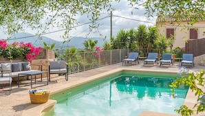 A swimming pool with lounge chairs, a wicker basket, and a view of mountains. - Holiday Home 'Numero Uno' with Sea View, Wi-Fi and Air Conditioning (Buger)