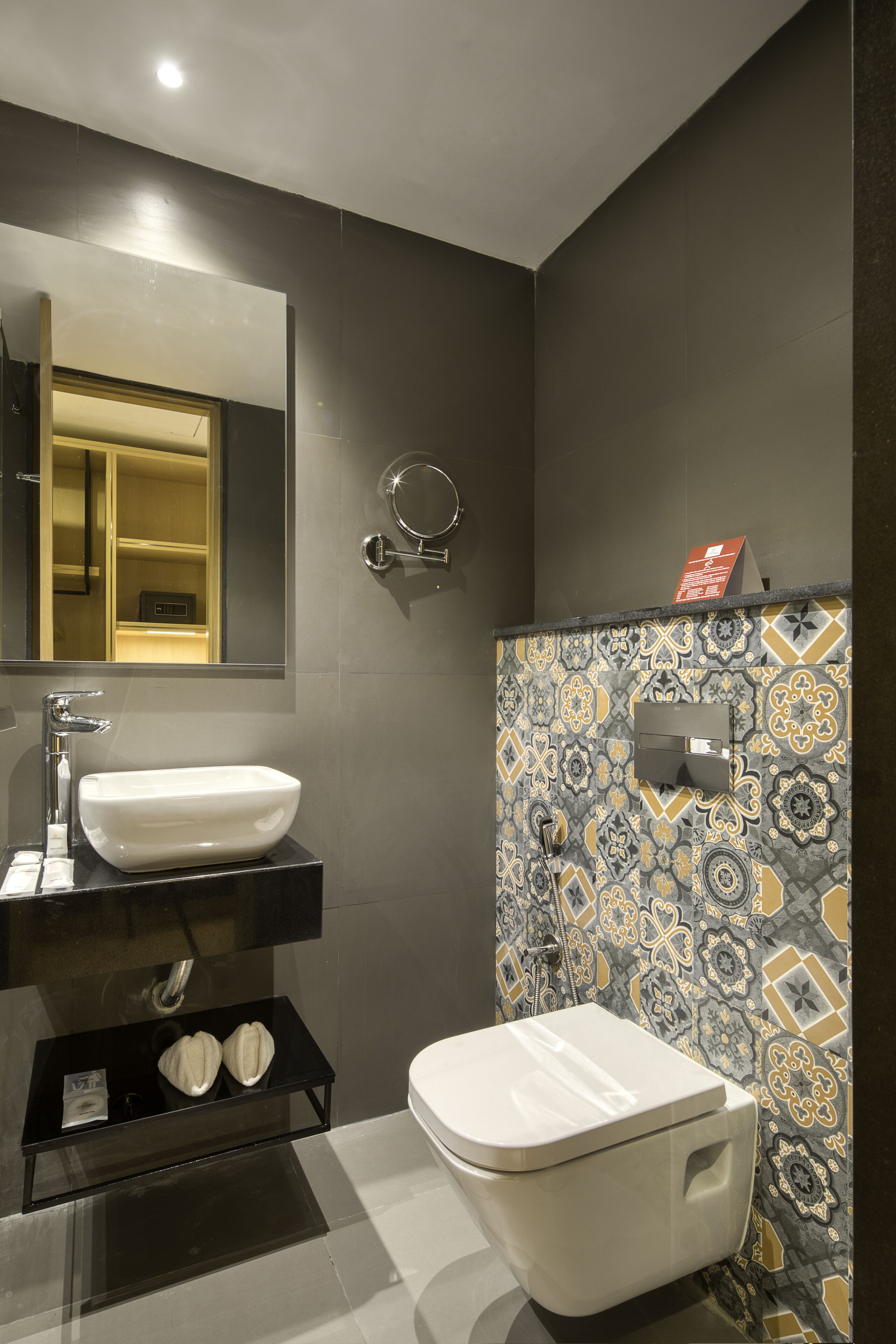 Un bany modern amb un lavabo blanc, un vàter i un mirall.