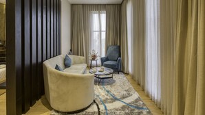 A modern living room with a beige sofa, a blue armchair, and a coffee table. - Le Foliage by TGI (Bengaluru)