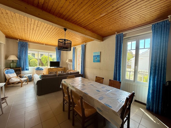 A dining area with a table, chairs, and a television.