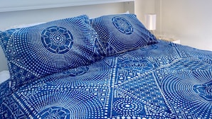A bedroom with a large bed, two windows, and a view of a landscape. - Casa Azure - quaint studio with a mediterranean touch (Kangaroo Valley)