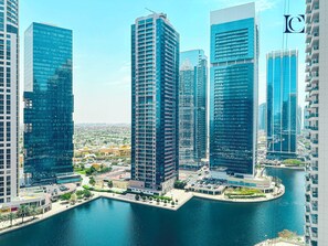 A high-rise urban area with modern buildings, a waterfront, and a marina.