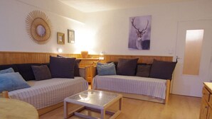 A cozy living room with two sofas, a coffee table, and a wooden cabinet. - Tignes: Classic Apartment with Lake View, 5 Sleeps (Tignes)