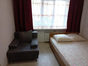 A small room with a sofa and a bed. - Apartment on Zavodskaya 1 (Tyumen)