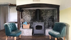A cozy room with a stone fireplace, two teal armchairs, and a wooden floor. - House for 8 people with swimming pool, south west of france (Montcuq-en-Quercy-Blanc)