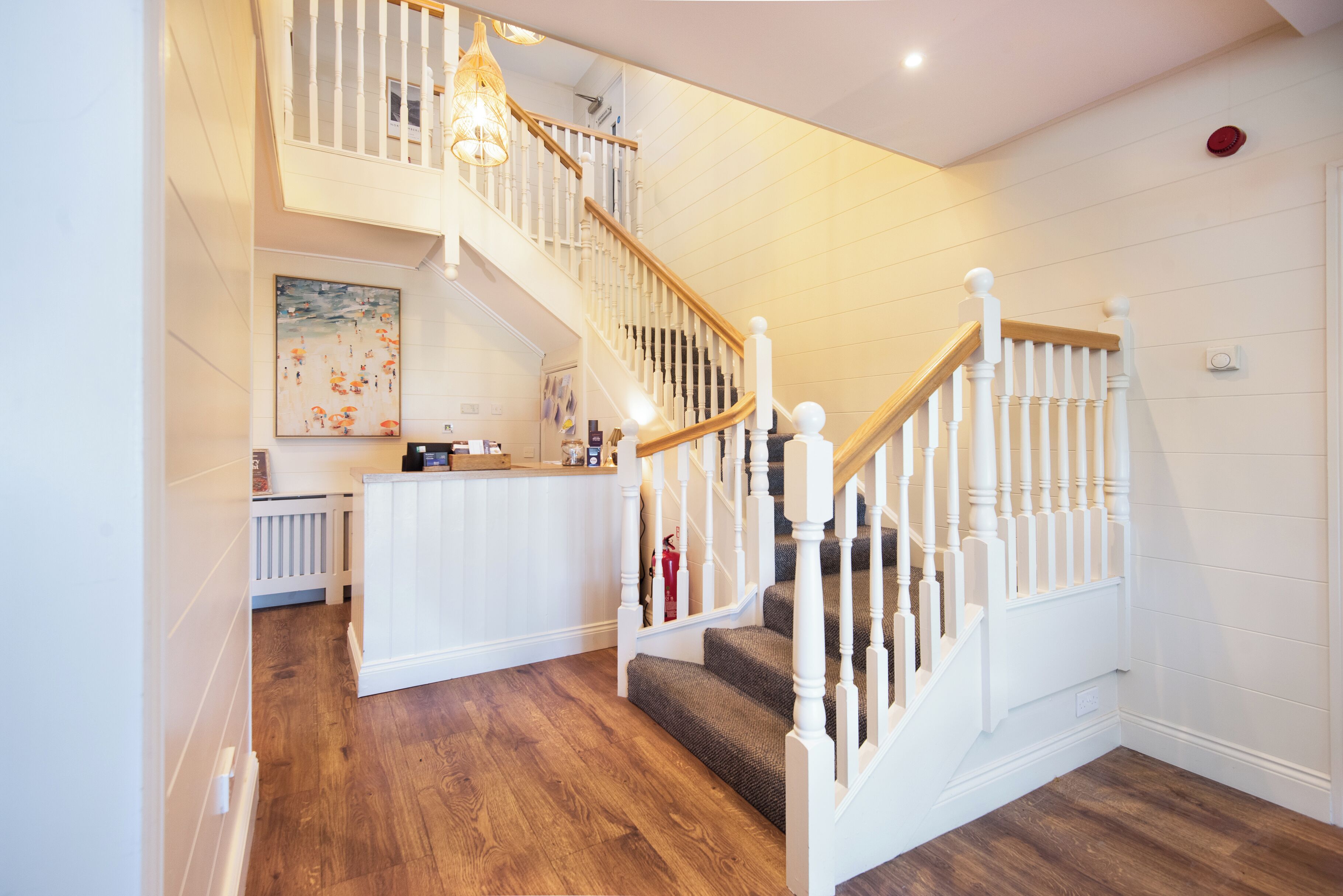 A staircase with white railings and wooden steps leading to an upper level.