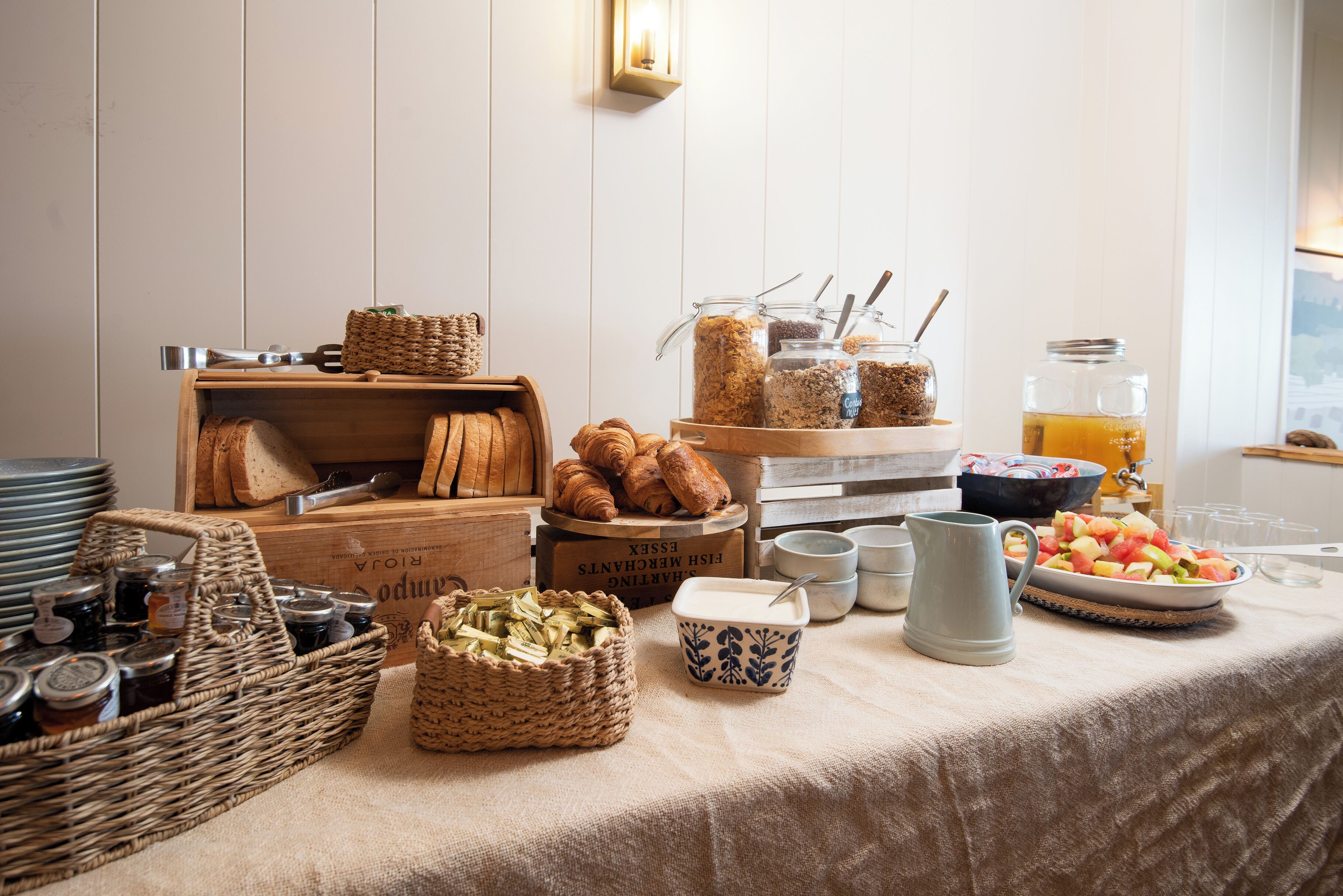 Un buffet de petit-déjeuner comprenant du pain, des viennoiseries et des fruits.
