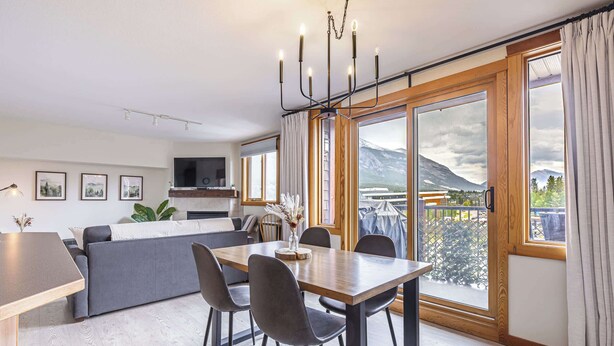 Une cuisine moderne avec un coin repas, de grandes fenêtres et une vue sur les montagnes.