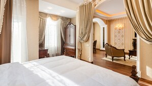 A spacious bedroom with a large bed, a wooden wardrobe, and a classic armchair. - GREGORY Boutique Hotel Chisinau (Chisinau)