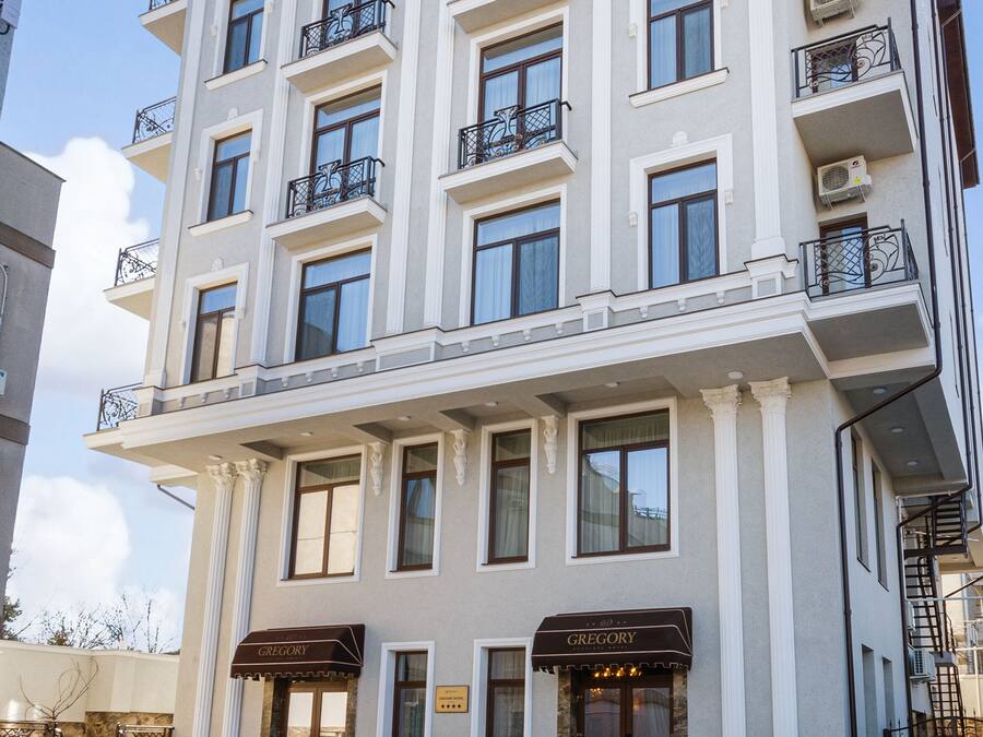 A multi-story hotel with a classical facade, balconies, and a ground-level entrance.