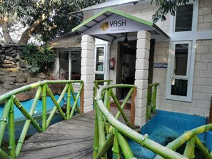 A reception area with a sign reading "YASH HOLIDAYS" and a reception desk. -  Leisure Inn Resort by NHospitality (Cheyyur)
