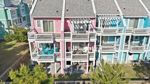 Un immeuble résidentiel à plusieurs étages, doté de balcons, d’une piscine et surplombant un ciel dégagé.