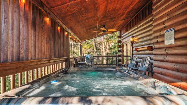 A wooden cabin with a hot tub, wooden deck, and a ceiling fan. - Book for fall now! Enjoy our hot tub and deck! (Gatlinburg)