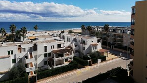 Een kustwoongebied met moderne gebouwen, een strand en een heldere lucht.