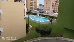 Un quartier résidentiel doté d’une piscine, de pelouses verdoyantes et d’immeubles à plusieurs étages.