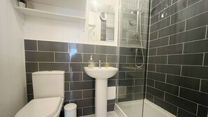 A modern bathroom with a toilet, sink, and shower. - Anstey Heights - Apartment 4 - Hopewell (Easton)