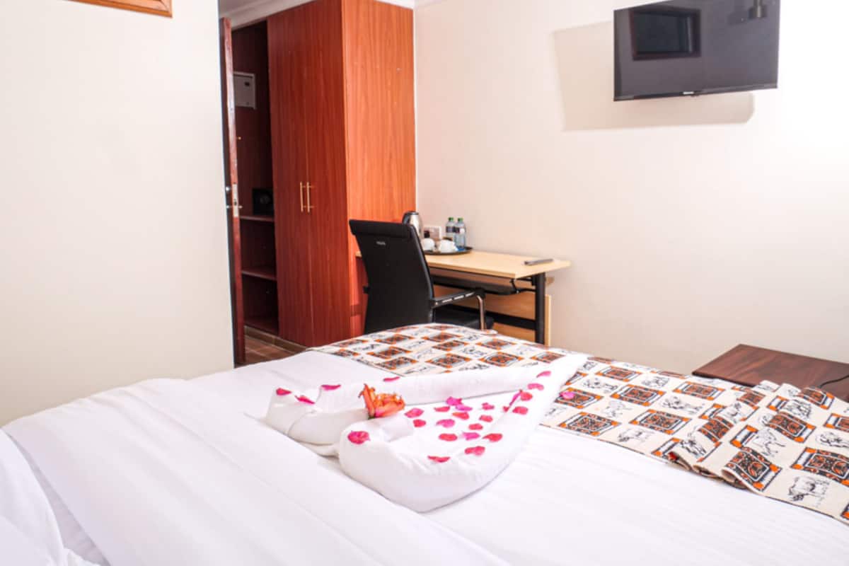 Une chambre d’hôtel comprenant un lit, un bureau, une chaise et une armoire.