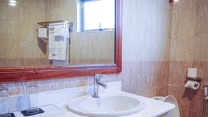 A bathroom with a white sink, a mirror, and a toilet. - PORI CITY HOTEL (Nairobi)