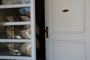A white door with a brass handle and a small brass plate.
