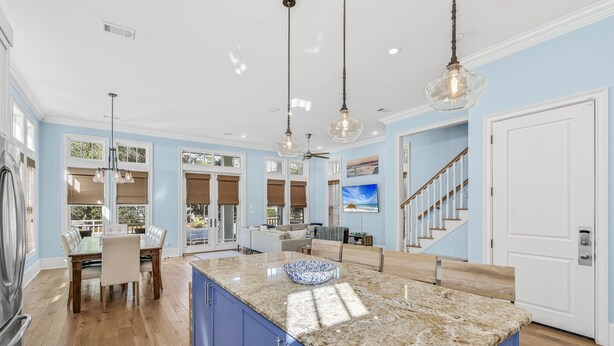 A spacious kitchen with a large island, blue cabinets, and a granite countertop.