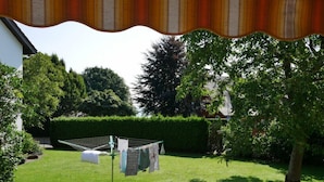 A well-maintained garden with a clothesline, neatly trimmed hedges, and a variety of trees. - New from 2022: beautiful 84 sqm vacation apartment in a top location with partial lake view (Langenargen)