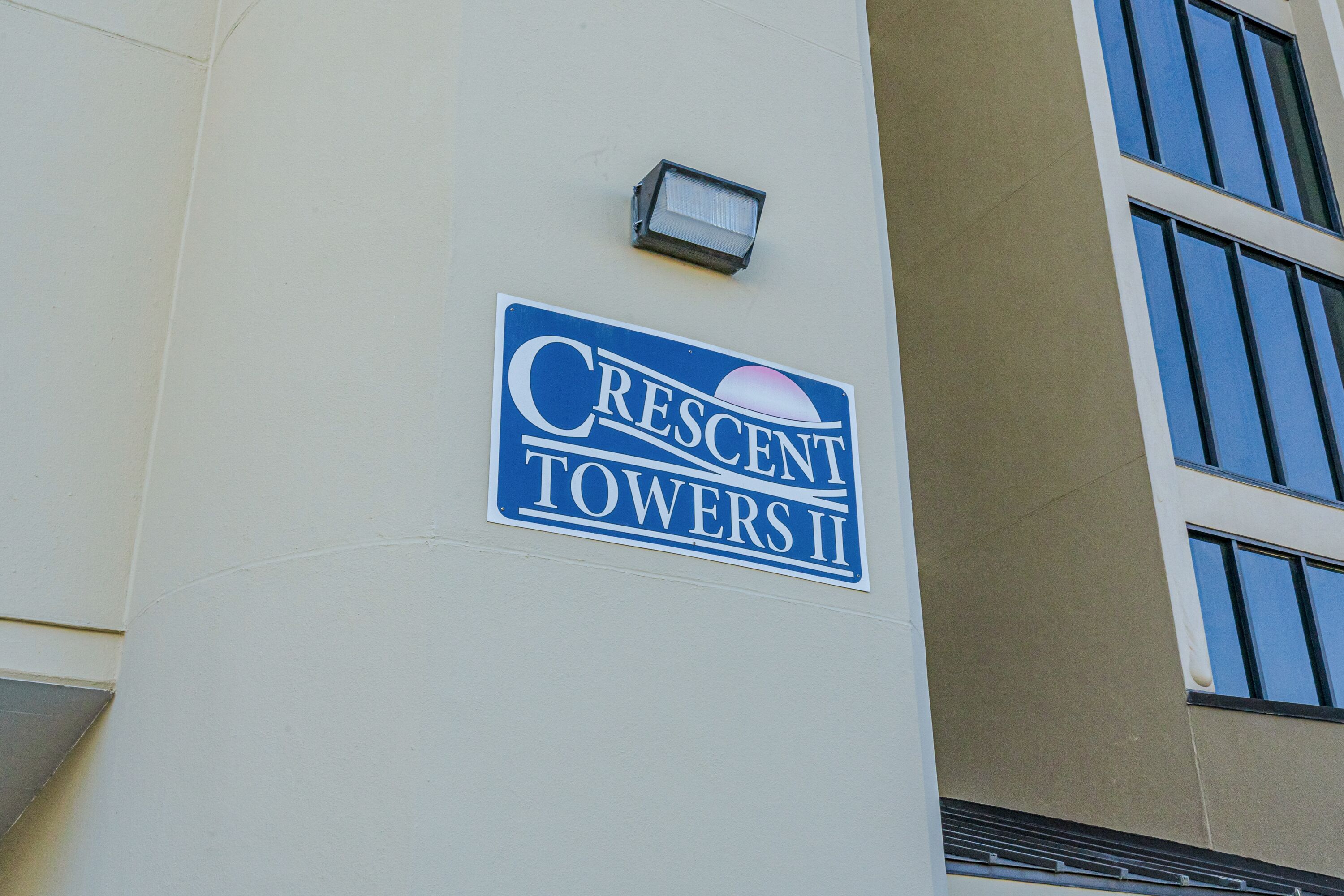 Schild für Crescent Towers II an einer Gebäudefassade.
