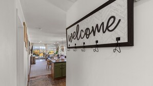 Una cocina moderna con un cartel de 'welcome', un comedor y vistas al exterior.