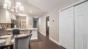 A modern kitchen with a dining area, white cabinetry, and a chandelier. - TB 12H  Bedroom/Three Bath unit in True Blue (Pawleys Island)