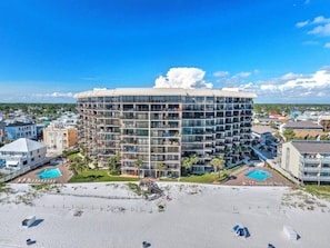 A modern hotel with a circular design, multiple balconies, and a pool area.