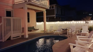 A pool area with a hot tub, lounge chairs, and string lights. - Close to beach, on golf course in TCC!  Private pool, spa, and 6 seat golf cart! (Corolla)