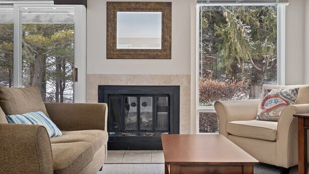 Una sala de estar con chimenea, dos sofás y una mesa de centro.