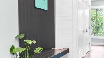 A modern interior with a dark wooden wall, a sign reading "CITY SIDE LOFTS," and a potted plant.