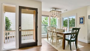 A dining area with a wooden table and chairs, a chandelier, and large windows with a view of greenery. - **The Caddy's Shack** 1 story home with Club Cards Optional (Fripp Island)