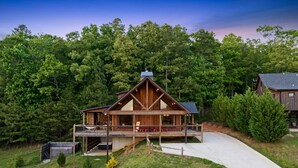 A wooden cabin with a porch, surrounded by trees. - 10% Off Member Deal•10 min>Town•Mtn Views•Hot Tub•Movie Theater•Firepit•Pond (Morganton)
