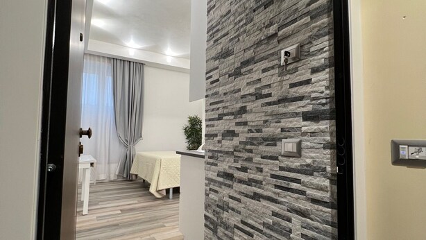 Un pasillo de diseño moderno, con un revestimiento de pared texturizado y piso de madera.