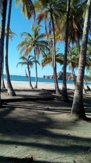 Ranta lähistöllä, aurinkotuoleja, rantapyyhkeitä