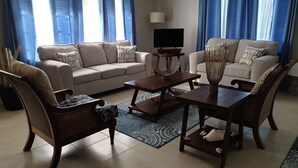 Una sala de estar con dos sofás, una mesa de centro y un televisor.