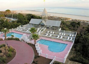 A resort with a large pool area, multiple decks, and a view of the beach.