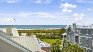 A view of a beach with a house in the foreground. - Wayfarer cottage with elevator and Heated pool! (St Simons Island)