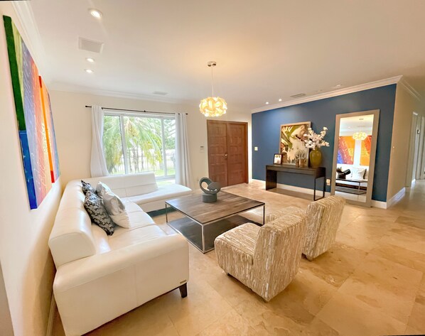 A modern living room with a white sofa, a glass coffee table, and a decorative lamp.