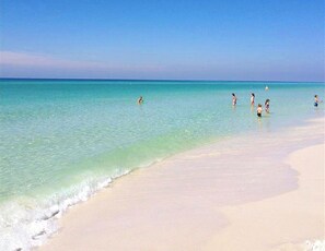 Una playa con aguas turquesas cristalinas y una orilla arenosa.