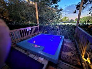 Une table de billard avec un panneau néon, entourée d’une terrasse en bois et d’un panneau d’avertissement concernant la présence de poulpes.