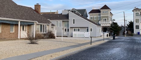 A residential street with houses, a sidewalk, and a road.